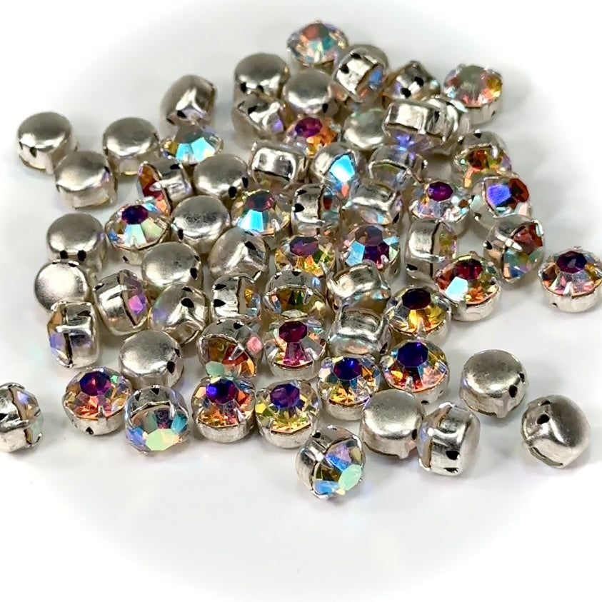 A collection of pointed back rhinestones with silver settings and multicolored AB coating, intended for sew-on applications.