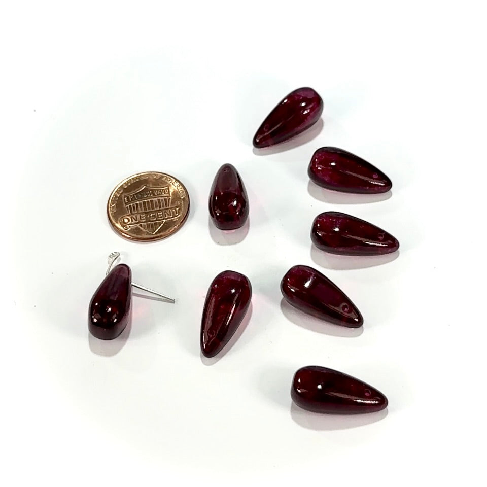 Set of dark red teardrop-shaped earrings on a white background with a coin for scale.