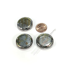 Three small metallic components with leads on a white background, one next to a penny for scale.