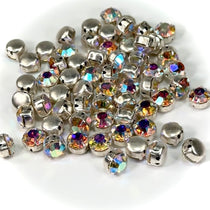 A collection of pointed back rhinestones with silver settings and multicolored AB coating, intended for sew-on applications.