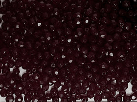 A close-up image of faceted round garnet-colored glass beads with a glossy finish.